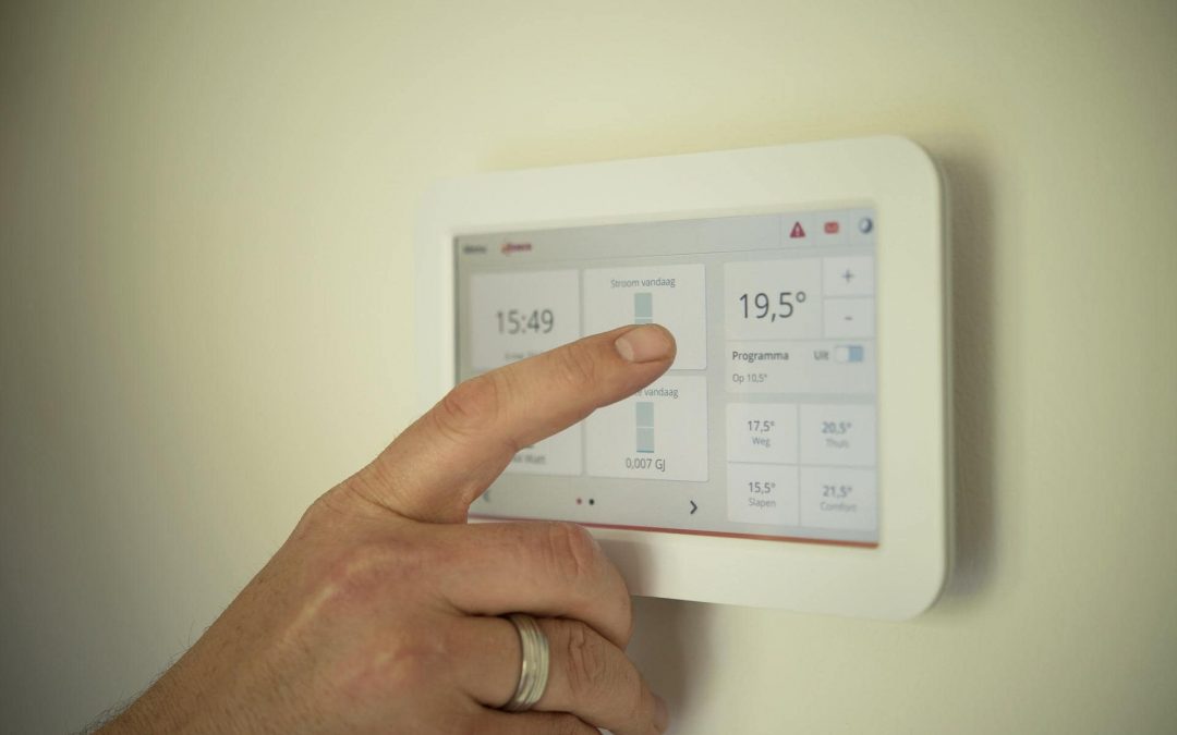 A Finger Pressing A Digital Thermostat